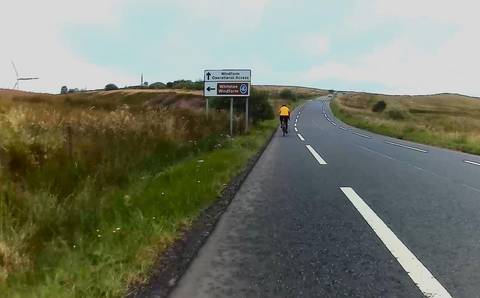 Single cyclist on long road climb.