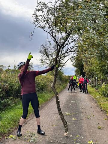 Cyclist pointing at fallen road hazard.
