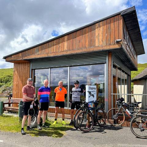 Four cyclists in front of Osprey exhibition building.