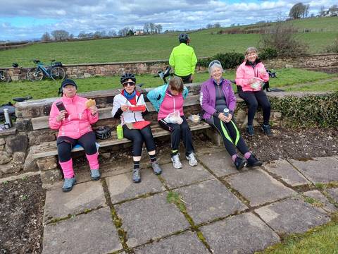 Cyclists eating lunch in outdoor location.